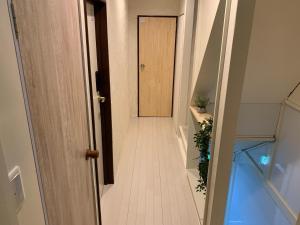 un pasillo vacío con una puerta en una casa en From Scratch Hanare en Tokio