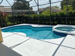 a swimming pool in a yard with a fence at Cozy Villa With South Facing Pool in Davenport +42 photos