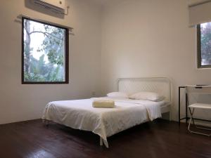 a white bed in a room with a window at Suri Homestay, Taiping in Taiping