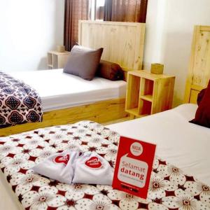 a hotel room with two beds with a sign on it at Rumah Roso Homestay in Yogyakarta