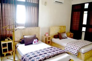 a bedroom with two beds and a window at Rumah Roso Homestay in Yogyakarta