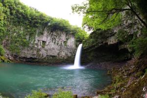 a waterfall in a river in a canyon at Guesthouse EL CAMPO in Gokase +10 photos