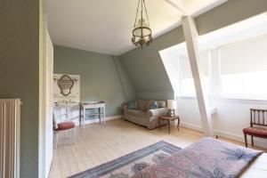 a living room with a bed and a table at Appartement bourgeois Les Etoffes de Mulhouse in Mulhouse
