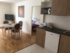 a kitchen and living room with a table and chairs at MEDICIS HOME Nice Saint -Laurent- Du -Var in Saint-Laurent-du-Var