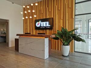a reception desk in a lobby with a sign on the wall at Otel Hotel Sibu in Sibu