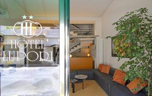 a living room with a couch in front of a hotel lobby at Hotel Lupori in Viareggio