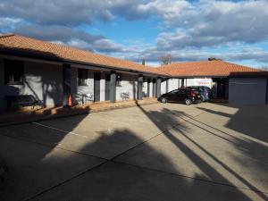 a building with a car parked in a parking lot at Snowdream Motel in Berridale