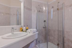 a bathroom with a sink and a shower at Epavlis Hotel & Spa in Kamari