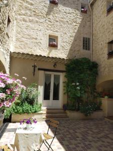 una casa con flores y una silla delante de ella en Le Térébinthe B&B, en Lauris