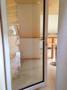 a sliding glass door with a chair in a room at 2-Zimmer Ferienwohnung,Parterre,Sitzplatz,Garage in Adelboden