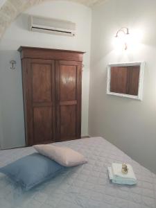 a bedroom with a bed and a wooden cabinet at Ai Carrettieri in Trani