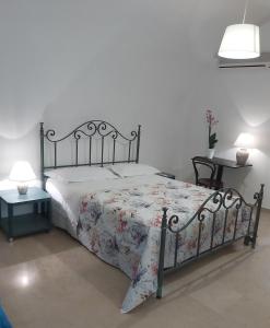 ein Schlafzimmer mit einem großen Bett mit einer Blumenbettdecke in der Unterkunft Ai Carrettieri in Trani