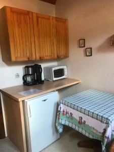 una piccola cucina con forno a microonde e frigorifero di Gîte et chambres d'hôtes Les Framboises a Katzenthal