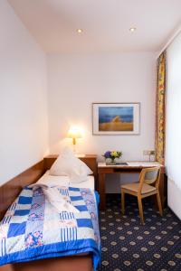 Habitación de hotel con cama y escritorio en Inselhotel Ihnken, en Norderney