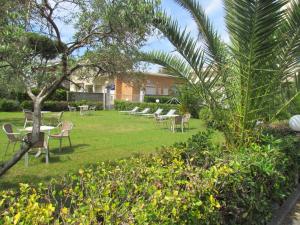 un groupe de tables et de chaises dans une cour dans l'établissement Hotel Villa Colombo, à Lido di Camaiore