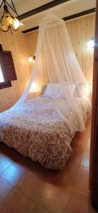 um quarto com uma cama e uma rede mosquiteira em La casita Rubí en ZAFIRO LAGUNAZO Parque Natural del Río Mundo em Riópar