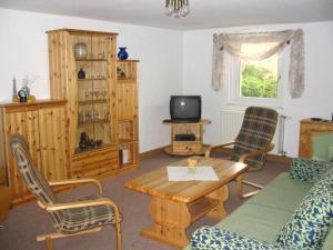 a living room with a couch and a table and chairs at Ferienhof Schwäbe in Lommatzsch