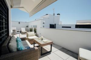 un balcone con divano e tavolo su un edificio di Attic with terrace- 1Bd 1Bth- Corral del Rey a Siviglia