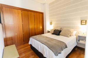 una camera con un grande letto e un armadio in legno di Attic with terrace- 1Bd 1Bth- Corral del Rey a Siviglia