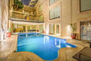 a large swimming pool in a large building at Grand Plaza Hotel - Takhasosi Riyadh in Riyadh