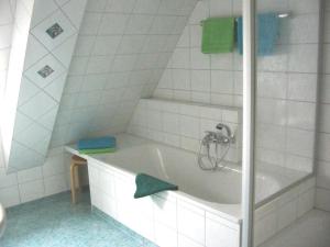 ein Badezimmer mit einer Badewanne und einem grünen Handtuch in der Unterkunft Ferienhof Schwäbe in Lommatzsch