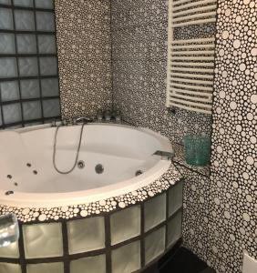 uma banheira na casa de banho com um espelho em Open Space UltraCentral em Piteşti