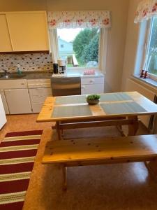 a kitchen with a table and a bench in it at Bestemorhuset in Kariel