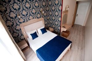 a bedroom with a blue and white bed with blue pillows at Artefes Hotel Old City in Istanbul