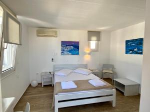 a white bedroom with a bed and two tables at Maria Elena - Suite Home in Mikonos