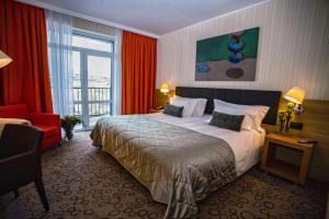 a hotel room with a large bed and a window at Domina Hotel Novosibirsk in Novosibirsk