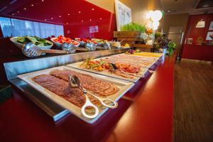 a buffet line with different types of meats and vegetables at Domina Hotel Novosibirsk in Novosibirsk