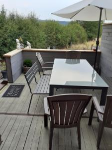 a patio with a table and chairs and an umbrella at Vic Va la Vie in Éprave
