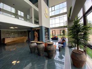 a lobby with three large vases in a building at HUNNU HOTEL in Ulan-Ude