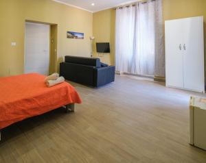 a room with a bed and a couch and a television at Royal Dante in Naples