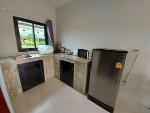 a kitchen with a stainless steel refrigerator and a window at Malinee Resort in Bang Tao Beach