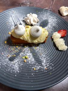 kawałek jedzenia na niebieskim talerzu z truskawką w obiekcie Hotel Restaurant Cousseau w mieście Parentis-en-Born