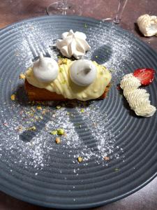 a piece of food on a blue plate with a strawberry at Hotel Restaurant Cousseau in Parentis-en-Born