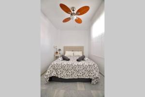 - une chambre avec un lit et un ventilateur de plafond dans l'établissement Estupendo apartamento el la mejor ubicación, à Benalmádena
