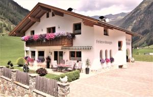 a house in the mountains with flowers at Apart Harmonie in Kaunertal