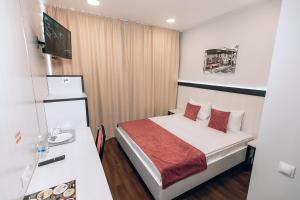 ein Hotelzimmer mit einem Bett mit roten Kissen in der Unterkunft RedFox Hotel in Barnaul