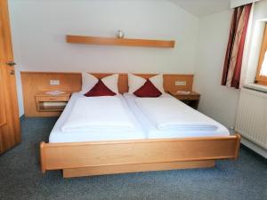 カウナータールにあるApart Harmonieのベッドルーム1室(赤い枕2つ付きのベッド1台付)