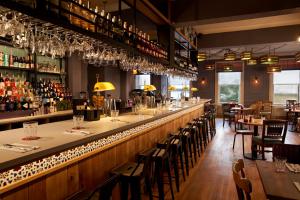 a restaurant with a long bar with tables and chairs at Bike & Boot Inns Scarborough - Leisure Hotels for Now in Scarborough