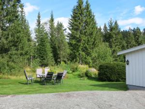 a table and chairs in a yard with trees at Holiday Home Øygårdsheia - SOO615 by Interhome in Grimstad