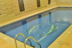 a swimming pool with a blue and white tub at Carawan Al Fahad Hotel in Riyadh