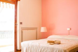 sypialnia z łóżkiem z białą pościelą i lampką w obiekcie Grande appartamento sul lungomare a Villa Rosa (TE) w miejscowości Alba Adriatica