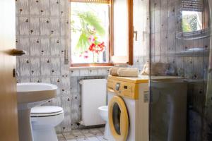 een badkamer met een wastafel, een toilet en een raam bij Grande appartamento sul lungomare a Villa Rosa (TE) in Alba Adriatica