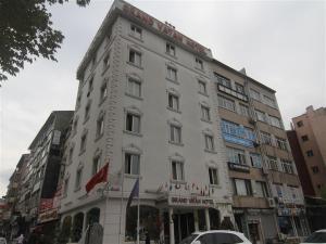 un grand bâtiment blanc au coin d'une rue dans l'établissement GRAND VATAN HOTEL, à Istanbul
