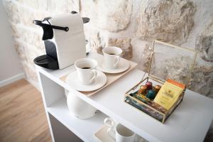 a white shelf with cups and a coffee maker at Live Laugh Love Dubrovnik Luxury Rooms in Dubrovnik