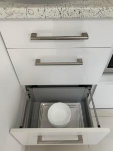 a drawer in a kitchen with a white bowl in it at Look of Dreams - Apartamenty Słoneczny i Księżycowy in Będzin