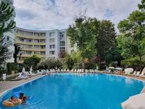 two people swimming in a large pool in a hotel at Yassen Holiday Village in Sunny Beach